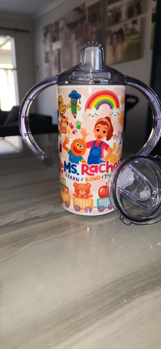 Kids sippy cup with two handles printed with a learning presenter, a rainbow and toy blocks