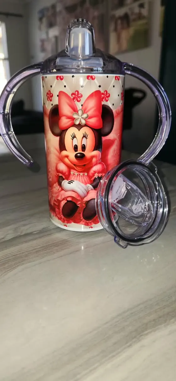 Kids sippy cup with two handles printed with a bow-wearing cartoon mouse on pink polka dots