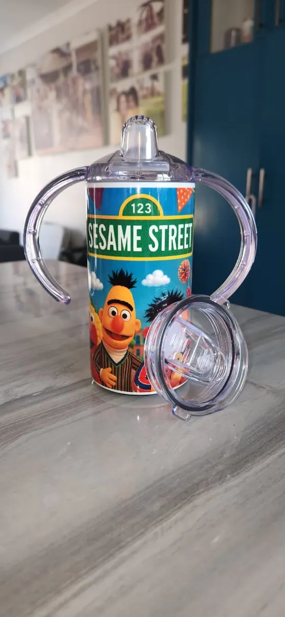 Kids sippy cup with two handles printed with street puppet characters and a 123 sign