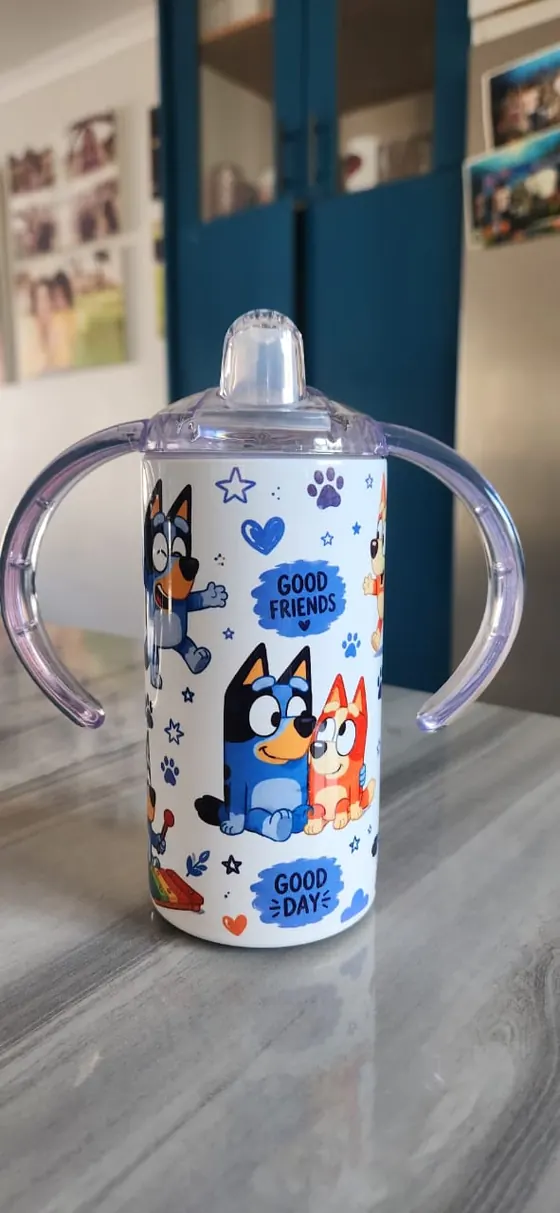 Kids sippy cup with two handles printed with a blue cartoon dog family and paw prints