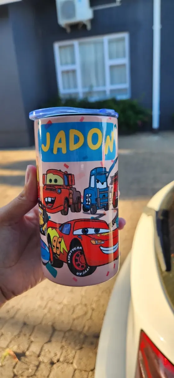 Kids sippy cup with two handles printed with cartoon racing cars and the name JADON
